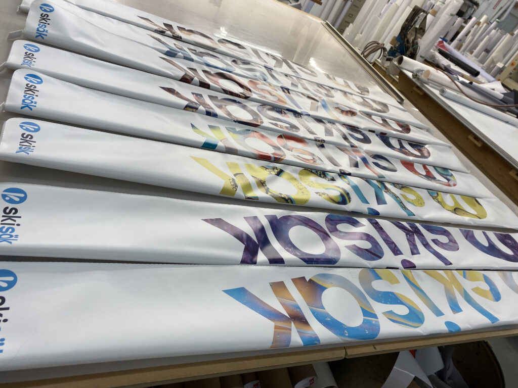 Plusieurs sacs Skisäk imprimés de visuels colorés, à l'atelier
