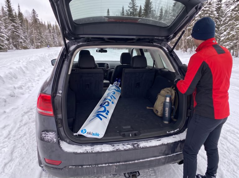 Sac de ski de fond Skisäk dans le coffre d’un VUS, au départ d’une piste enneigée