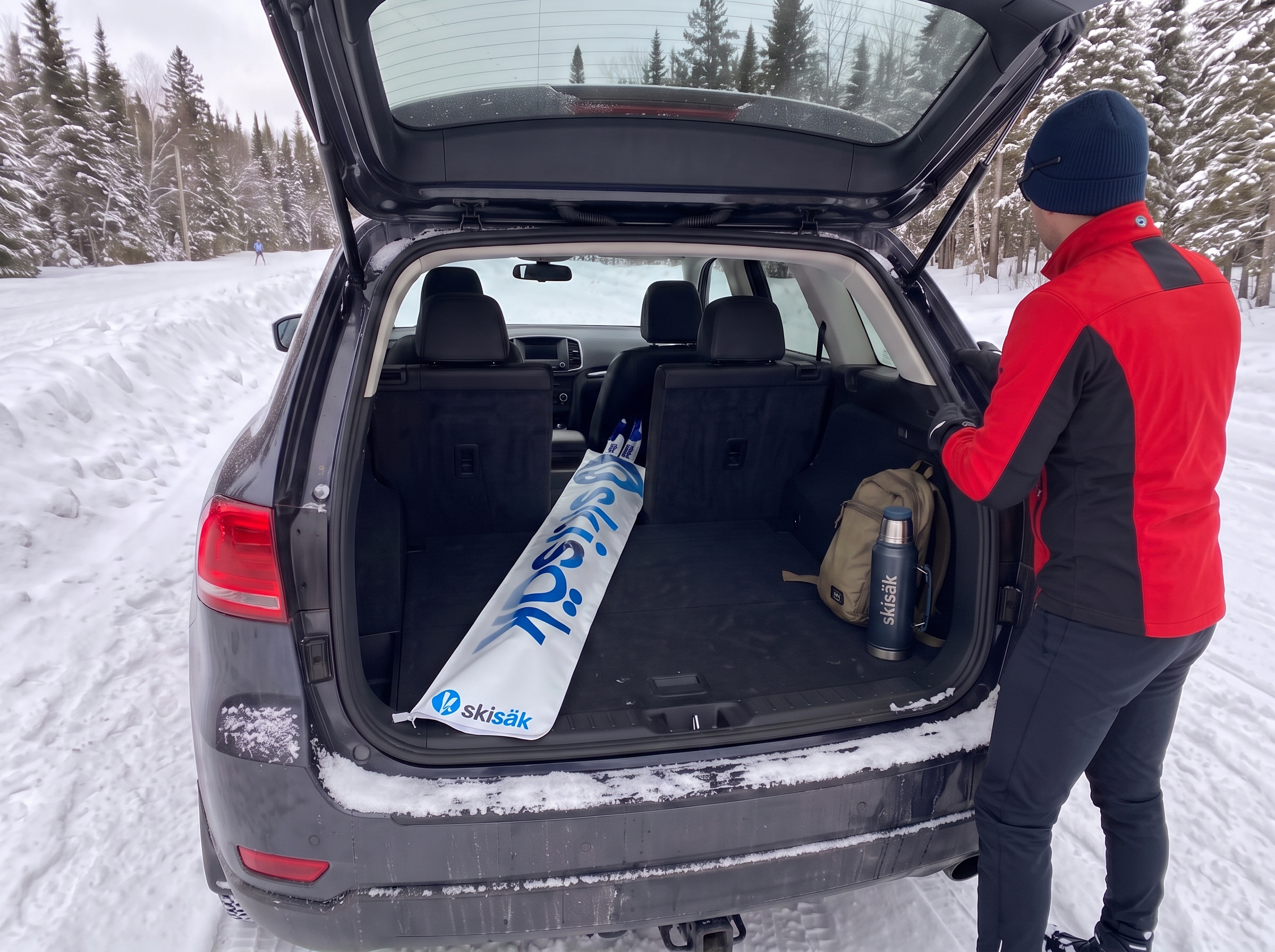 Sac de ski de fond Skisäk dans le coffre d’un VUS, au départ d’une piste enneigée